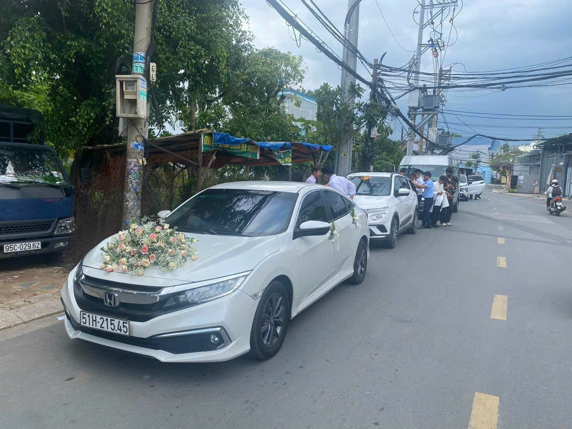 Đoàn xe cưới: một chiếc xe hoa sang trọng 4 chỗ (Mercedes/BMW) dẫn đầu, theo sau là xe 16 chỗ sạch sẽ. Dịch vụ thuê xe hoa, xe gia đình cưới hỏi trọn gói, cam kết ngày trọng đại hoàn hảo.